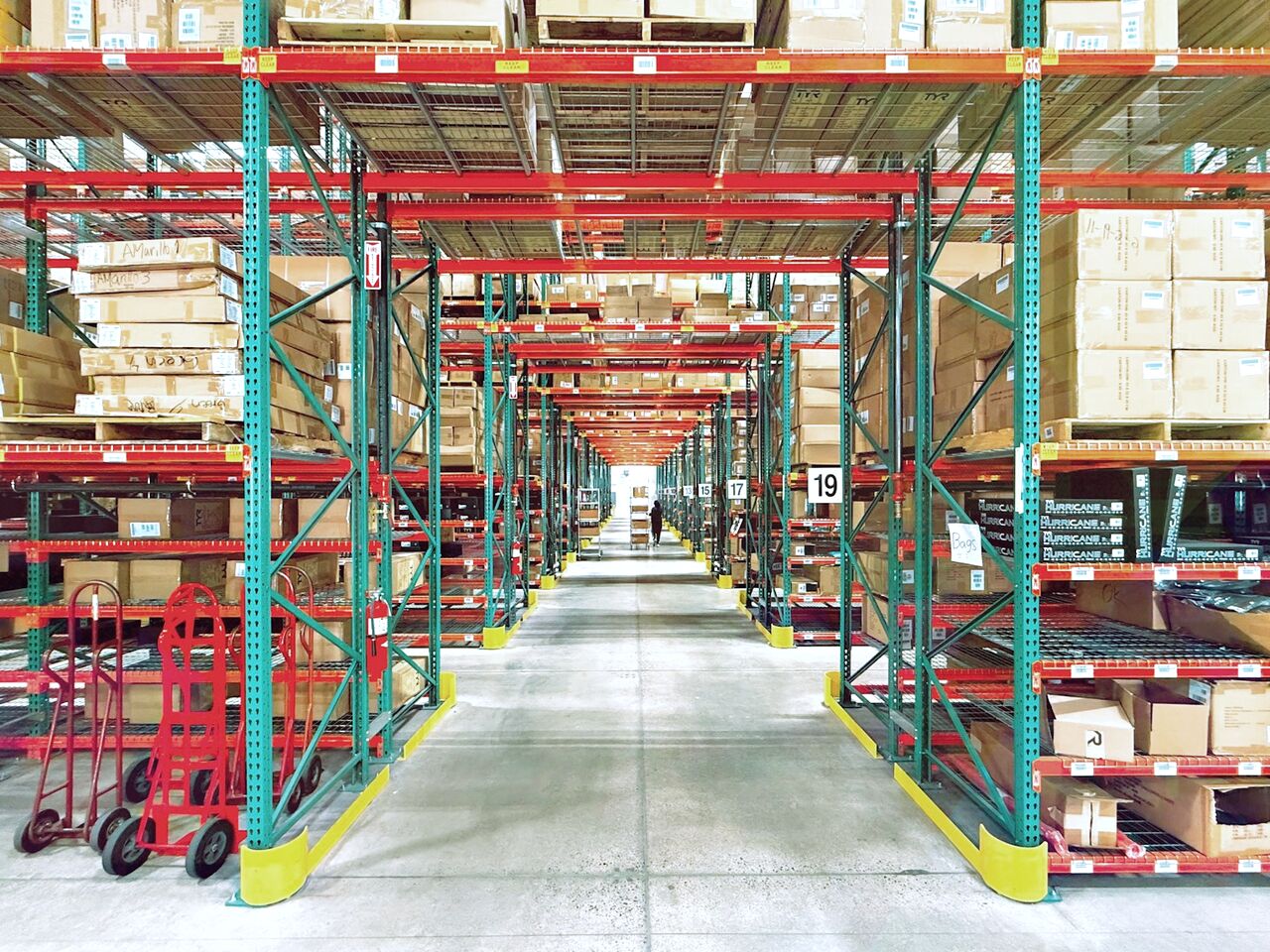 Aisle of organized HVAC parts and boxed inventory on warehouse racking at Advanced AC Supply in Houston